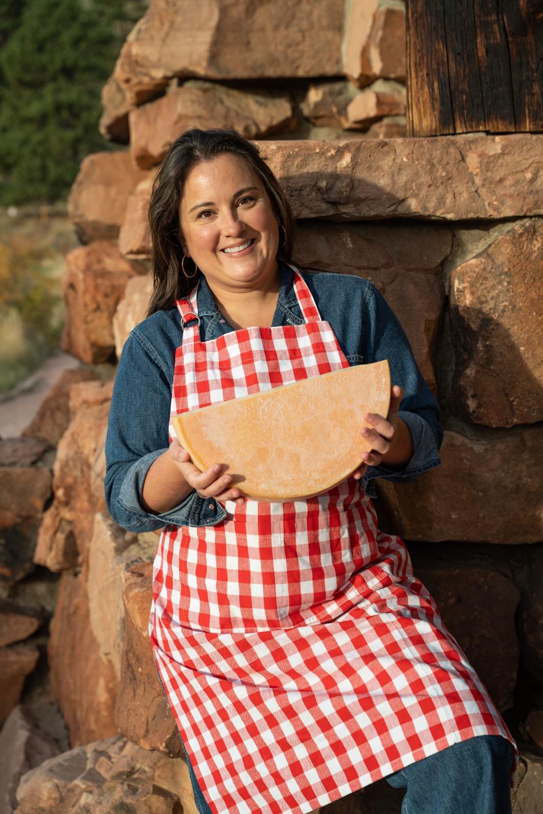 The Petit Chalet - Holding a Swiss cheese wheel